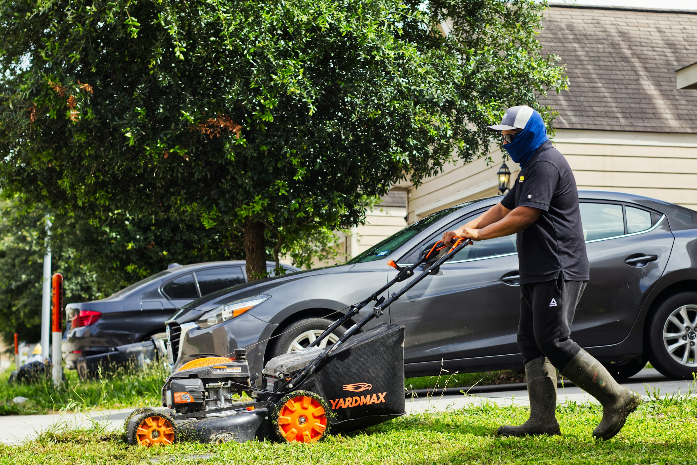 A lawn-care professional mowing a residential yard